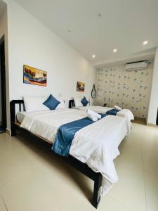 a bedroom with two beds with white sheets and blue pillows at candyinn in Hue