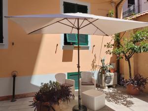 an umbrella and chairs on a patio in front of a building at La Casetta in La Spezia