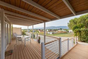 una terrazza in legno con tavolo e sedie. di Mobile home Margherita Agricamping Spineta a Cortona