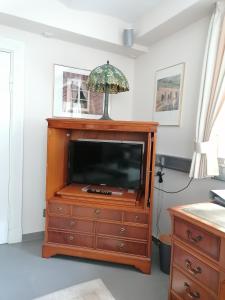 einen TV auf einer Kommode im Wohnzimmer in der Unterkunft Claas Villa am Meer in Bad Zwischenahn