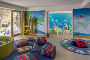 uma sala para crianças com uma área recreativa com brinquedos em Anantara Vilamoura Family Friendly em Vilamoura