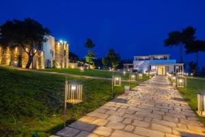 a stone pathway leading to a building at night at Masseria Baroni di Montesardo in Lido Marini