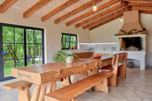 una cucina con un grande tavolo in legno e panche di Studio Apartment Petra 3 a Kirmenjak