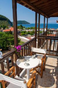 a table and chairs on a balcony with a view of the ocean at Aris Junior Studios Neo Klima Skopelos in Neo Klima