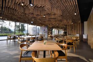 a restaurant with wooden tables and chairs and large windows at The Sun Hot Spring & Resort in Taichung