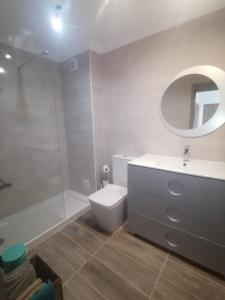 a bathroom with a toilet and a sink and a mirror at Apartment Poeta Aleixo in Faro in Faro