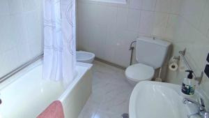 a bathroom with a toilet and a tub and a sink at Piso de Laura en primera planta in Lariño +9 photos