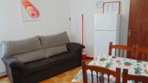 a living room with a couch and a table and a refrigerator at Piso de Laura en primera planta in Lariño