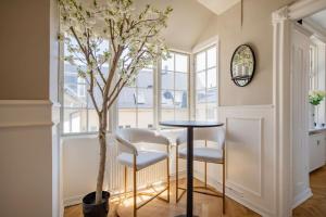 un comedor con mesa, sillas y un árbol en Amazing Royal Suite, en Helsingør