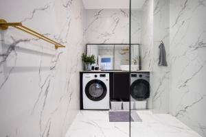 een wasruimte met een wasmachine en een spiegel bij Amazing Royal Suite in Helsingør