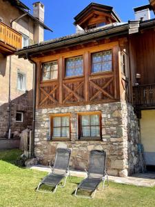 two chairs sitting in front of a house at Incantevole appartamento Saslonch, con parcheggio privato in Soraga