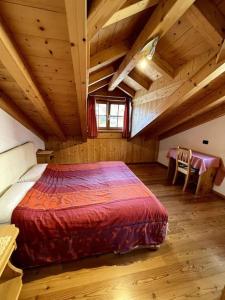 a bedroom with a large bed in a wooden room at Incantevole appartamento Saslonch, con parcheggio privato in Soraga