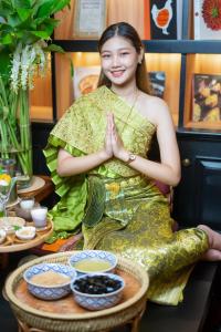 una mujer sentada en una mesa en una habitación haciendo yoga en Akara Hotel en Bangkok