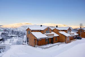 una grande casa in legno nella neve con la neve di Filefjellstuene a Tyinkrysset