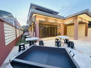 un patio con mesas y sillas en un edificio en B04 Modern Deluxe Homestay, en Johor Bahru