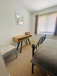 Schlafzimmer mit einem Schreibtisch, einem Bett und einem Stuhl in der Unterkunft No 2 Minhinnick Court in Tavistock