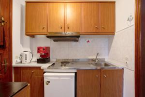 a kitchen with wooden cabinets and a sink at Areti Orfeas Apartment 3 in Vasilikos +21 photos