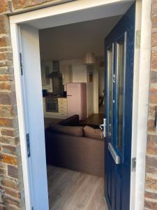 eine offene Tür zu einem Wohnzimmer mit einem Sofa in der Unterkunft No 2 Minhinnick Court in Tavistock