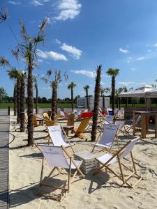 a row of chairs and palm trees on a beach at Skyfall Rooms in Eisenstadt