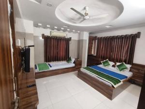 a bedroom with two beds and a ceiling fan at HOTEL SAI PRABHU INN in Shirdi