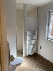 uma casa de banho com um WC branco e uma janela em Ferienhaus Leuchtfeuer em Norderney