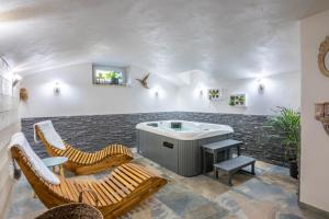a room with a bath tub and two chairs at le clos grillet in La Chambre