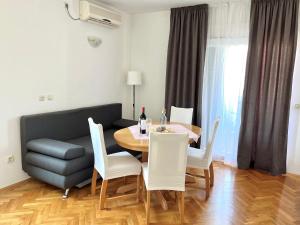 sala de estar con mesa, sillas y sofá en Apartment Troisa, en Kaštela