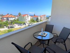 una mesa y sillas en un balcón con vistas a la calle en Apartment Troisa, en Kaštela