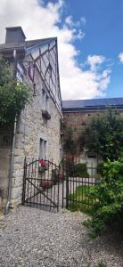 a stone building with a gate in front of it at Mante et Nana in Durbuy