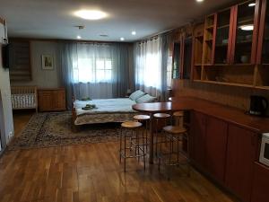 1 dormitorio con cama, mesa y taburetes en Villa Maia, en Papsaare
