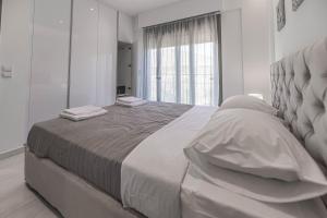 Habitación blanca con cama grande con almohadas en Demiani House en Lardos