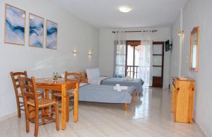 a living room with a bed and a table and chairs at Aris Junior Studios Neo Klima Skopelos in Neo Klima
