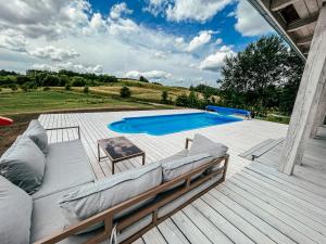 a patio with a couch and a swimming pool at Sielski dom z basenem w Rydzewie in Rydzewo