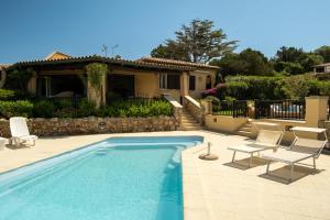 uma piscina com duas cadeiras e uma casa em Villa Baja Sardinia con piscina e vista em Baja Sardinia