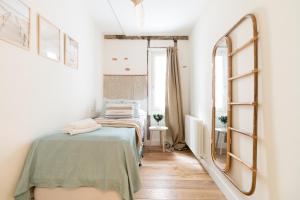 sypialnia z łóżkiem i lustrem w obiekcie Salazar by Staynnapartments w mieście Bilbao