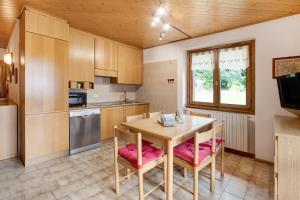 eine Küche mit einem Holztisch und Stühlen sowie einem Fenster in der Unterkunft Chalet Holly in Bormio + 13 Fotos