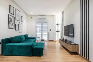 salon z zieloną kanapą i telewizorem w obiekcie Nazar Apartment- in the center of Athens w Atenach