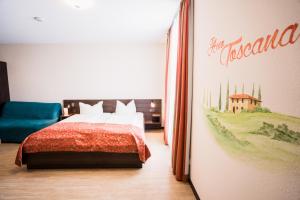 a bedroom with a bed and a painting on the wall at Hotel La Toscana Nähe Europapark in Ringsheim