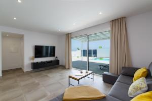 Ereza Villas Salitre في بويرتو كاليرو: غرفة معيشة مع أريكة وتلفزيون