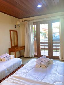 two beds sitting in a room with a balcony at Arbiru Beach Resort in Dili