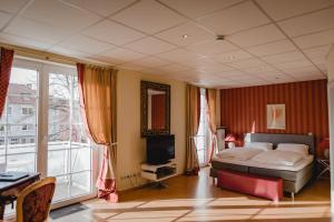 Hotel Stadtresidenz في هيلدسهايم: غرفة نوم فيها سرير وتلفزيون