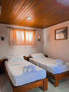two beds sitting next to each other in a room at Arbiru Beach Resort in Dili