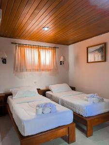 duas camas lado a lado em um quarto em Arbiru Beach Resort em Dili