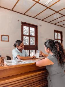 a woman standing at a counter in front of a hairivist at Arbiru Beach Resort in Dili