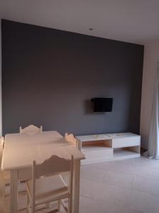 a living room with a table and a tv on a wall at Apartamento Avenida in Sal Rei