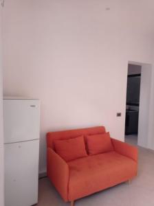 pomarańczowa kanapa w pokoju z białą ścianą w obiekcie Apartamento Avenida w mieście Sal Rei