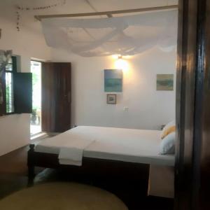 a bedroom with a bed in a room at Mango Beach House in Jambiani