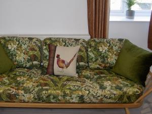 a couch with a chicken pillow on it at Pheasants Wander in Newquay