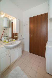 a bathroom with a sink and a wooden door at La Tana al sole in Brescia