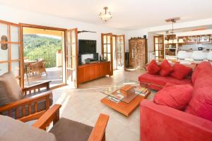 un soggiorno con divano rosso e TV di Casa gabriela a Calonge